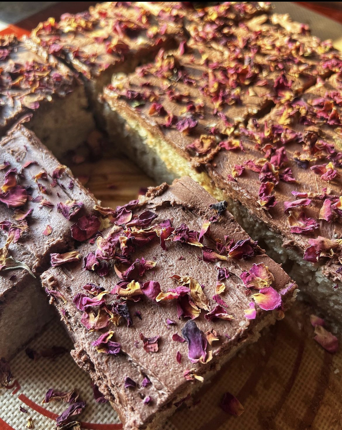 Cardamom cake slice with chocolate rose buttercream and edible rose petals