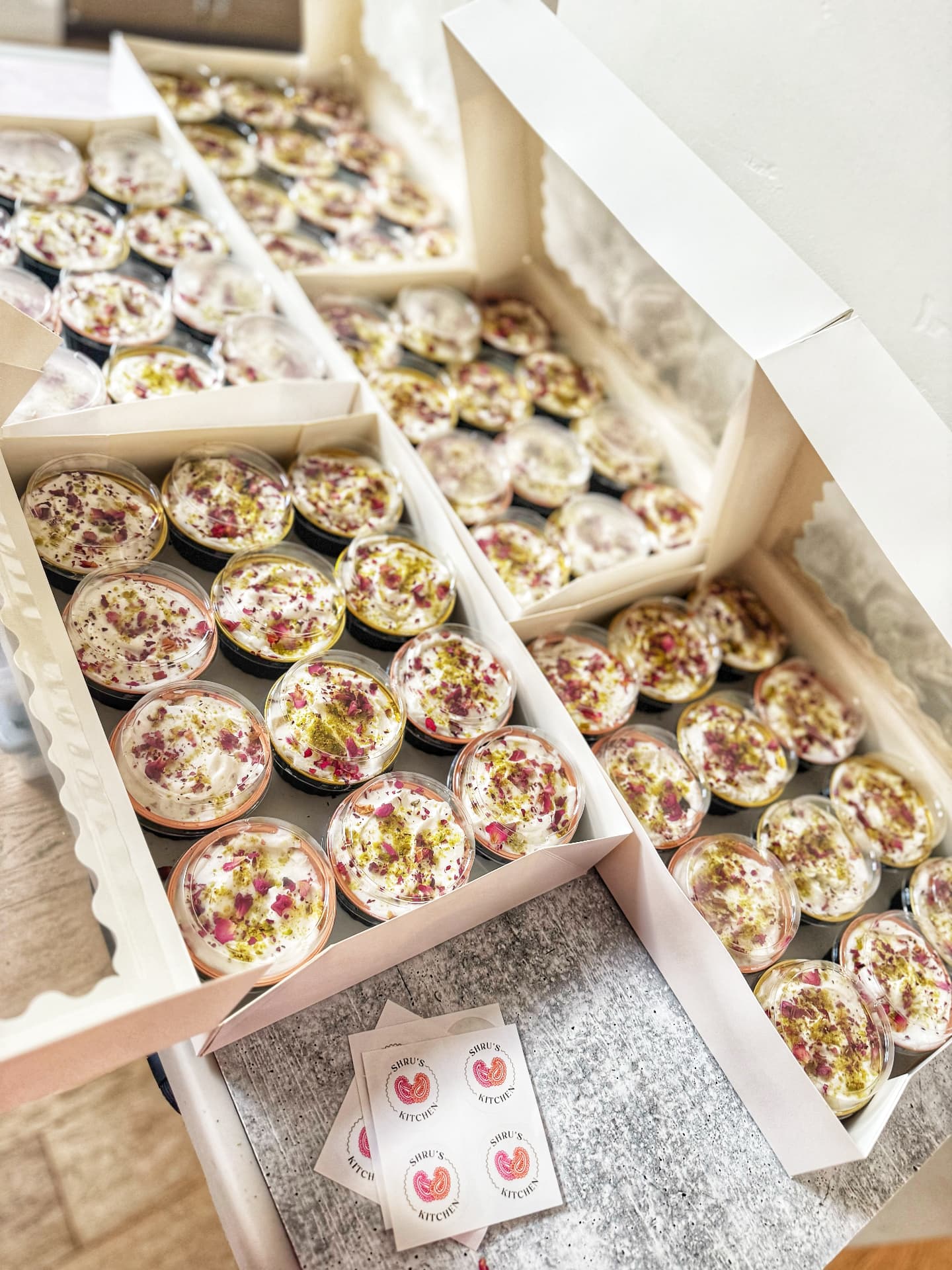 Boxes of individual rose and pistachio dessert cups for event catering